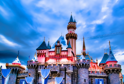 Disneyland castle in Anaheim California against a backdrop of blue and white clouds.